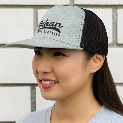 A picture of a lady wearing a custom printed cap with a logo on the front.